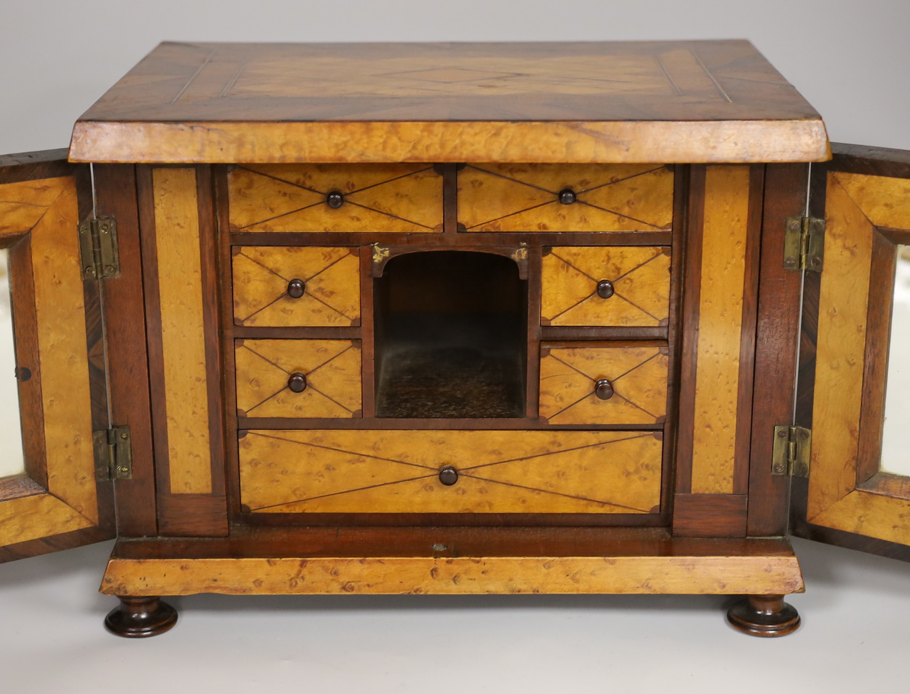 A 19th century rosewood and bird’s eye maple table cabinet. 24cm high. 32cm wide, 23cm deep